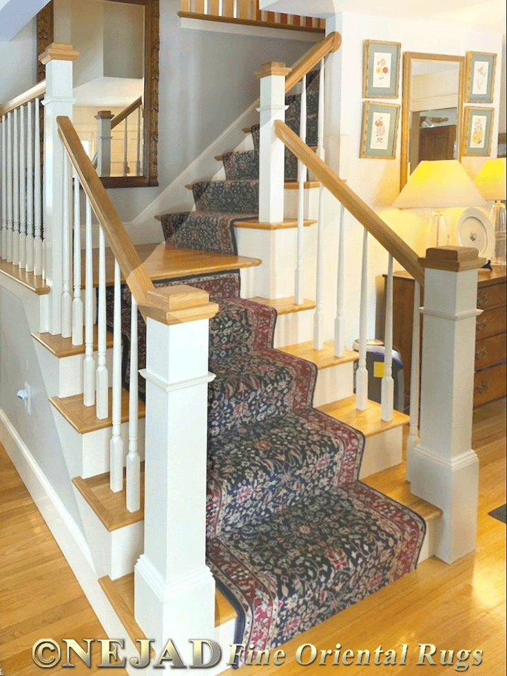 Rug runner installation on wooden staircase with railing