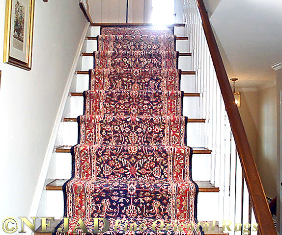 Hand-knotted wool stairway runner installation by Nejad Rugs.